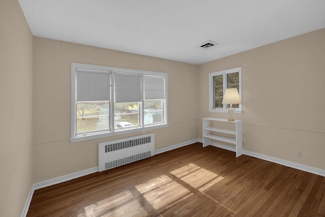 530 Powers Ln, Decatur, IL 62522 - empty room featuring radiator heating unit and wood finished floors