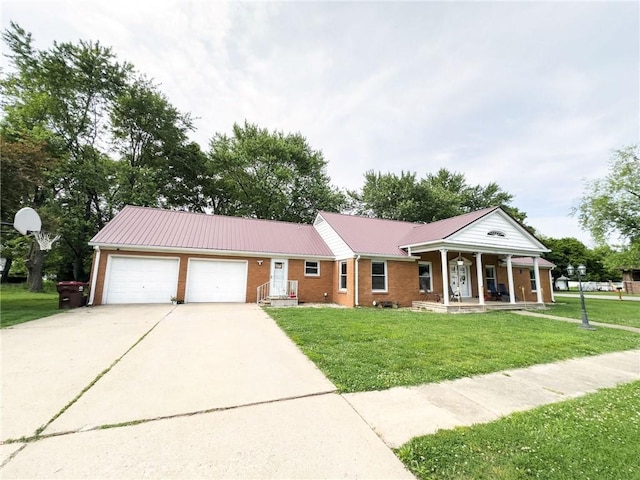201 N York St, Martinsville, IL 62442 - view of front of house featuring a garage, concrete driveway, a front yard, metal roof, and a porch