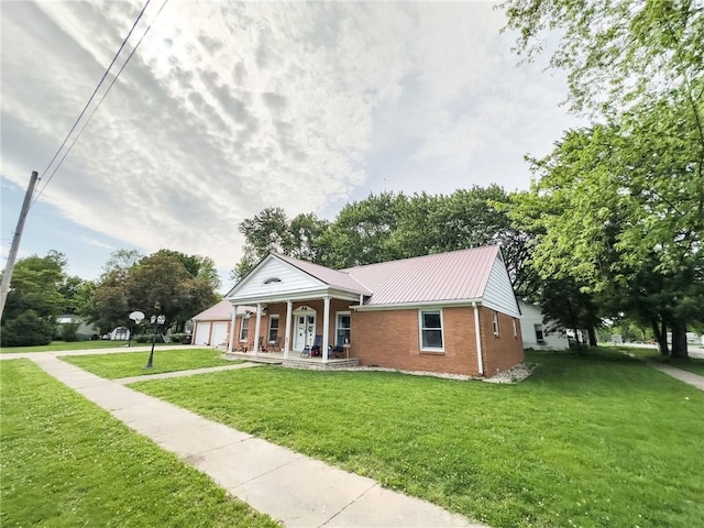 201 N York St, Martinsville, IL 62442 - neoclassical / greek revival house featuring covered porch, brick siding, a front yard, metal roof, and driveway