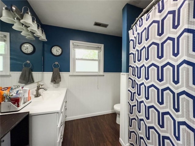 201 N York St, Martinsville, IL 62442 - full bathroom with a wainscoted wall, wood finished floors, toilet, vanity, and baseboards