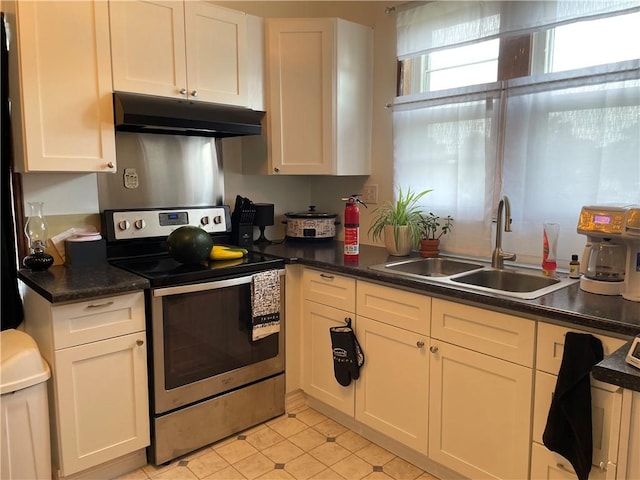 428 E Main St, Hoopeston, IL 60942 - kitchen with stainless steel range with electric stovetop, under cabinet range hood, dark countertops, and white cabinets