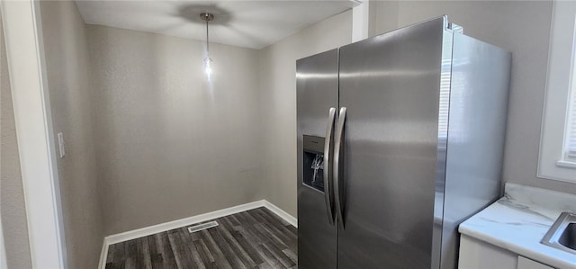 1420 E Main St, Decatur, IL 62521 - kitchen with stainless steel fridge, dark wood-style flooring, white cabinetry, light stone countertops, and pendant lighting