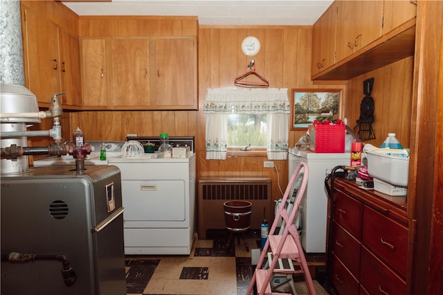 clothes washing area with washer and dryer and radiator