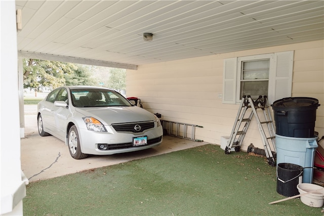 garage with a carport and a lawn