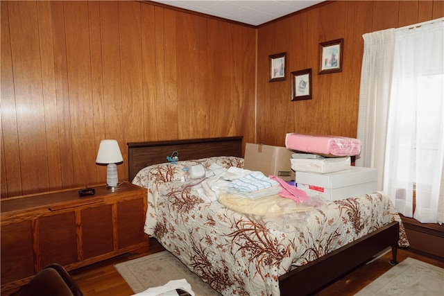 bedroom with wooden walls and hardwood / wood-style floors