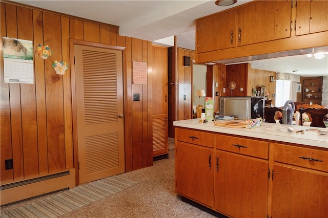 kitchen featuring light carpet and wooden walls