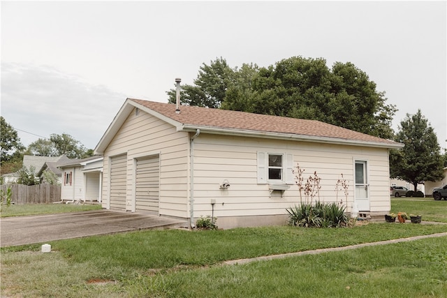 view of side of property featuring a yard and a garage