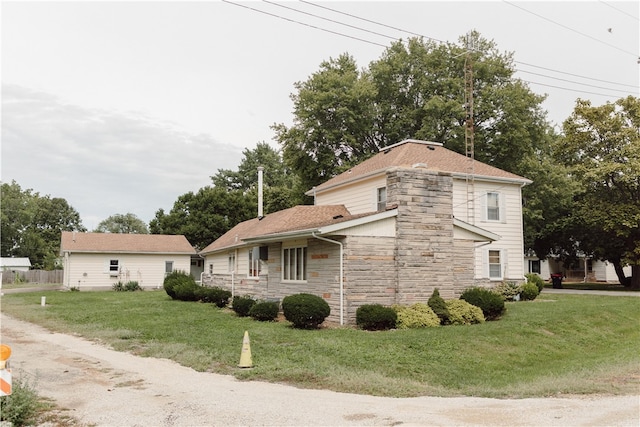 125 College St, Assumption, IL 62510 - view of side of home with stone siding, a lawn, and roof with shingles
