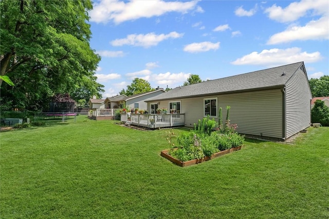 2506 Woodlawn Dr, Charleston, IL 61920 - back of property featuring a trampoline, a vegetable garden, a yard, and a deck