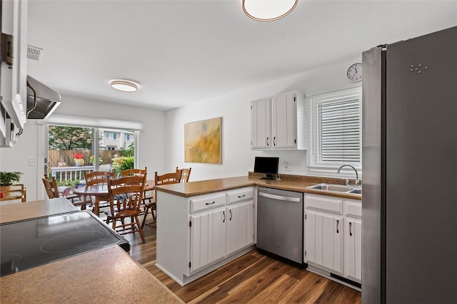 2506 Woodlawn Dr, Charleston, IL 61920 - kitchen featuring appliances with stainless steel finishes, a peninsula, dark wood-style floors, and white cabinetry