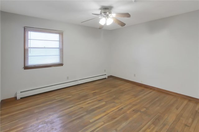 empty room with a baseboard heating unit, wood finished floors, baseboards, and a ceiling fan