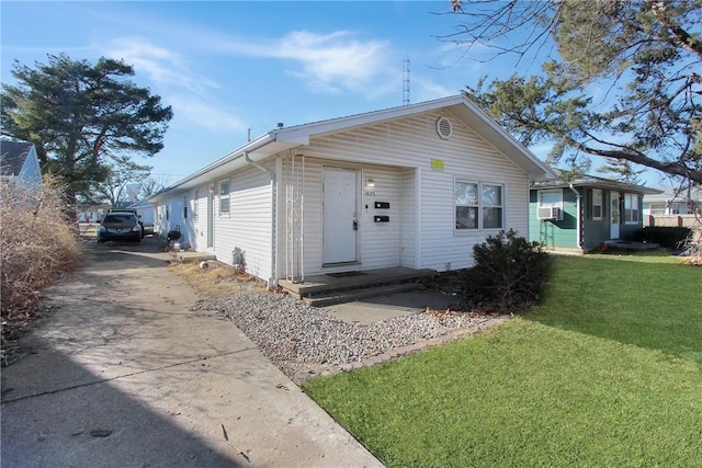 view of front of property featuring a front yard, cooling unit, and driveway