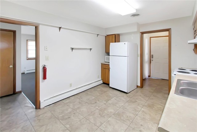 kitchen with white appliances, light countertops, brown cabinets, and a baseboard radiator