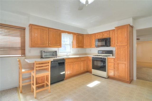 kitchen with light floors, a toaster, a sink, black appliances, and light countertops