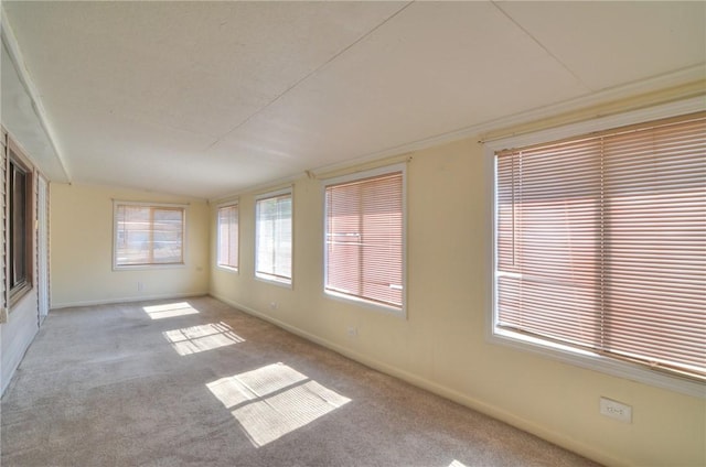 unfurnished room with lofted ceiling, carpet, and baseboards