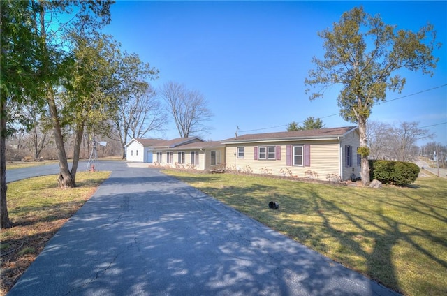 ranch-style home featuring a front lawn and driveway