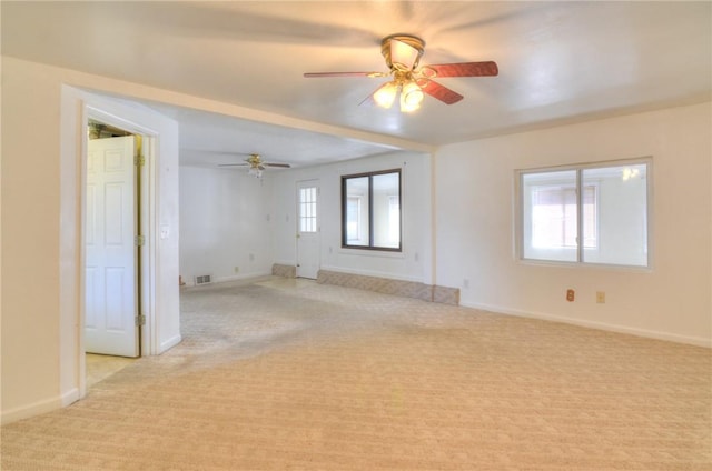 unfurnished room with light carpet, visible vents, ceiling fan, and baseboards