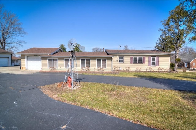 ranch-style house with aphalt driveway, a garage, and a front yard