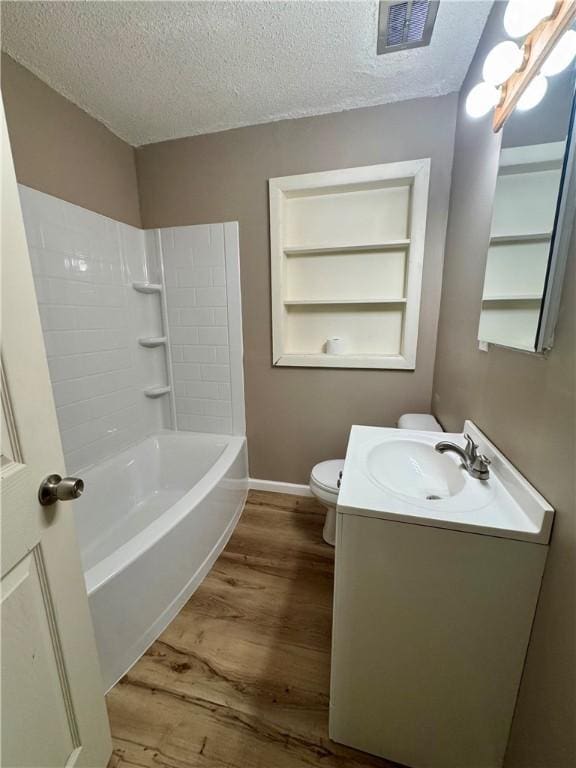 1821 Dakota Ave, Mattoon, IL 61938 - bathroom featuring a textured ceiling, toilet, vanity, wood finished floors, and baseboards