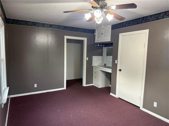 1821 Dakota Ave, Mattoon, IL 61938 - unfurnished bedroom with dark carpet, a textured ceiling, baseboards, ceiling fan, and an office area