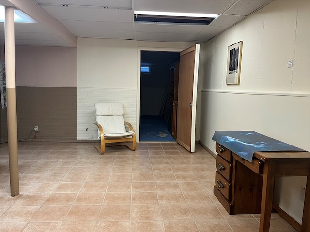 interior space featuring light tile patterned floors and a drop ceiling