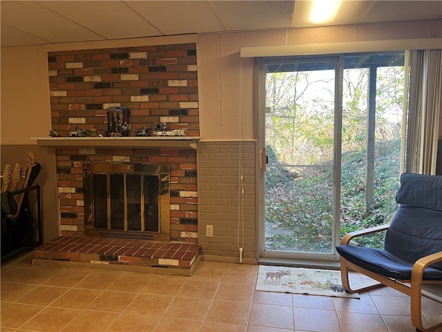 living room with a fireplace, plenty of natural light, and tile patterned flooring