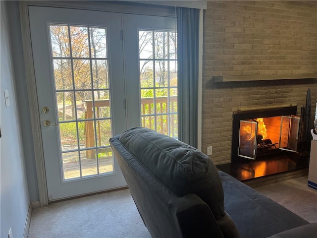 doorway featuring plenty of natural light, carpet flooring, and a brick fireplace