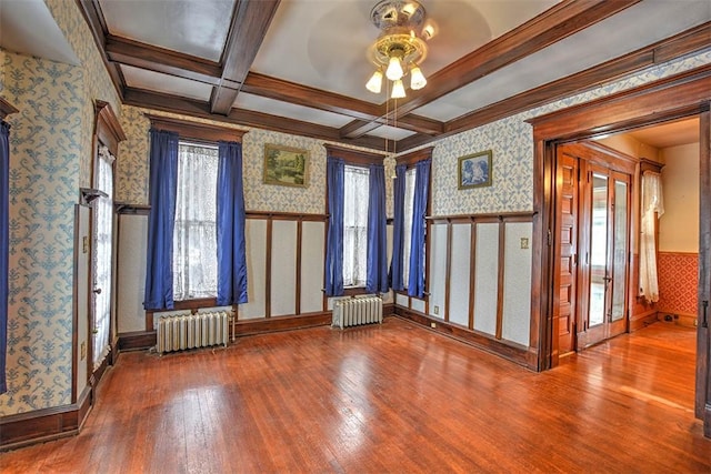 interior space with beamed ceiling, wood-type flooring, coffered ceiling, and radiator heating unit