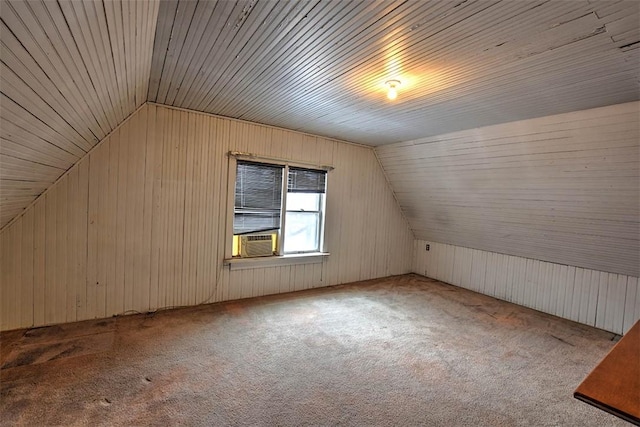 additional living space featuring light carpet, lofted ceiling, and wooden walls