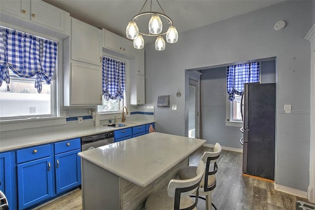 kitchen featuring appliances with stainless steel finishes, a center island, white cabinetry, blue cabinetry, and sink