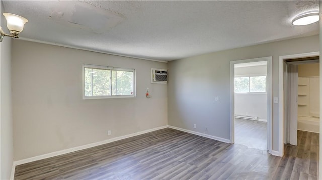 unfurnished room with dark wood-style floors, a textured ceiling, and plenty of natural light