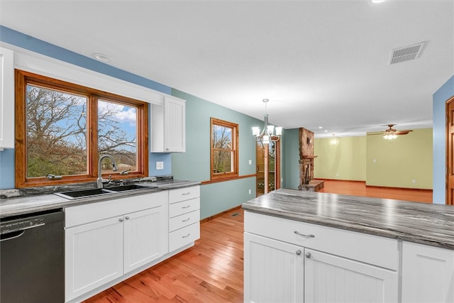 kitchen featuring white cabinetry, dishwasher, pendant lighting, light hardwood / wood-style floors, and ceiling fan with notable chandelier