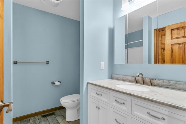 bathroom featuring vanity, toilet, wood-type flooring, and a shower