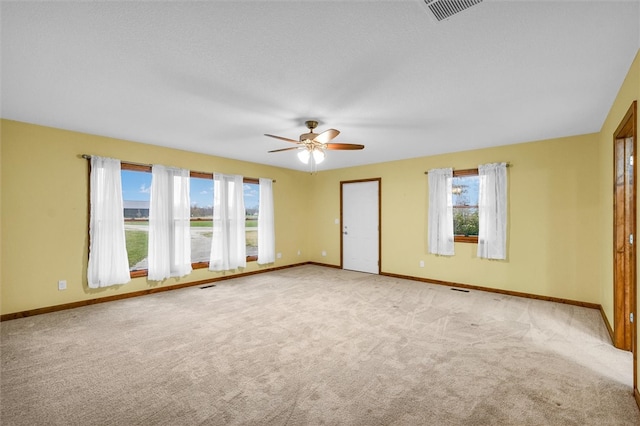 unfurnished room featuring a textured ceiling, ceiling fan, and light carpet