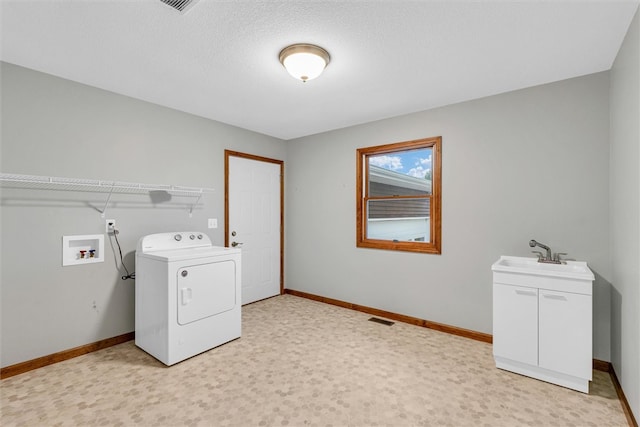 laundry area with light carpet, sink, a textured ceiling, and washer / dryer