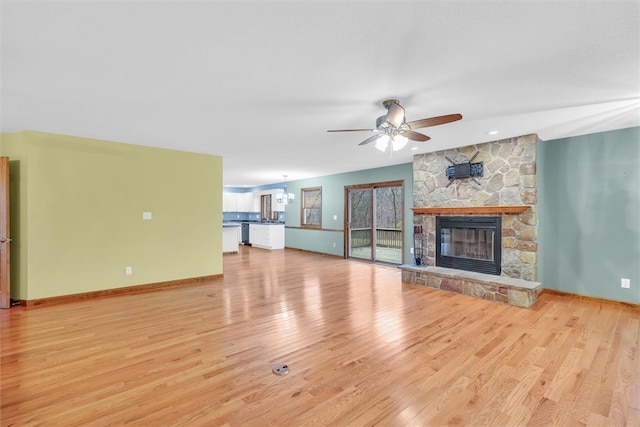 unfurnished living room with a fireplace, ceiling fan with notable chandelier, light hardwood / wood-style floors, and vaulted ceiling