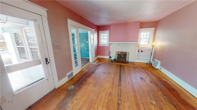 unfurnished living room featuring a fireplace and hardwood / wood-style flooring