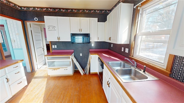 kitchen featuring black appliances, white cabinetry, and sink