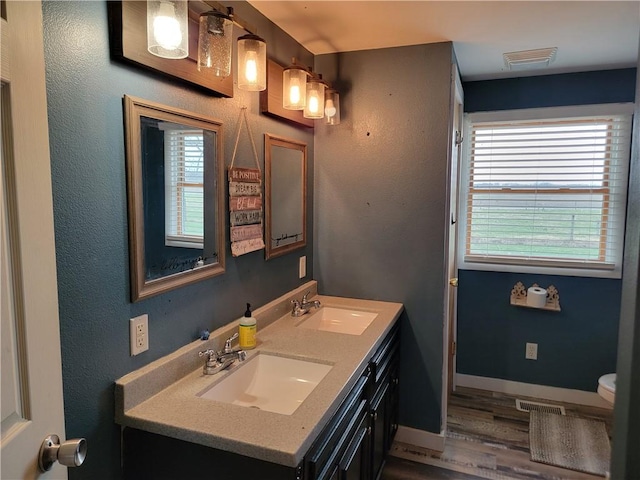 bathroom featuring visible vents, a sink, and plenty of natural light