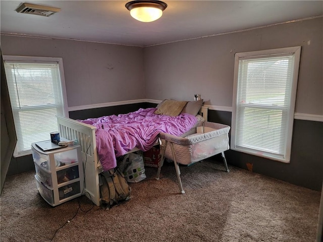 bedroom featuring carpet floors, multiple windows, and visible vents