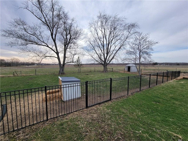 view of yard with fence and a rural view