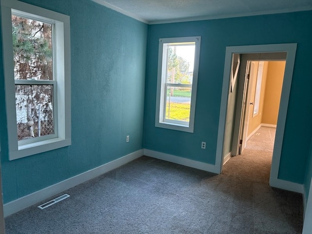 empty room with carpet floors and a textured ceiling