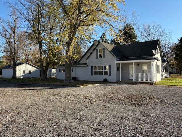 view of property with covered porch and an outdoor structure
