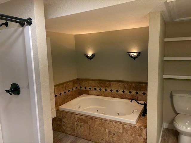 bathroom with hardwood / wood-style floors, tiled bath, and toilet