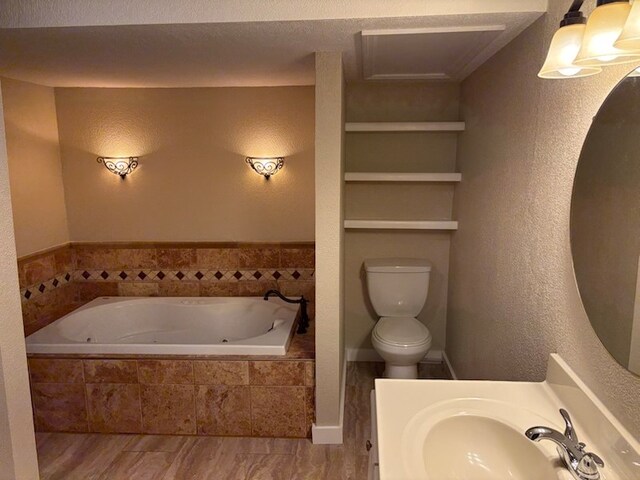 bathroom featuring tiled tub, sink, and toilet