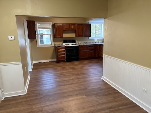 kitchen featuring white gas range oven and dark wood-type flooring