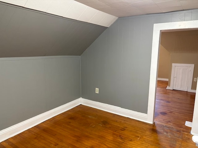 additional living space featuring hardwood / wood-style floors and vaulted ceiling