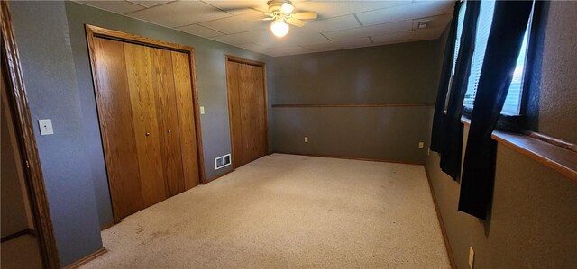 1006 N Koester Dr, Effingham, IL 62401 - unfurnished bedroom featuring carpet, a drop ceiling, a ceiling fan, and multiple closets