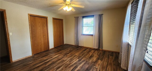 1006 N Koester Dr, Effingham, IL 62401 - unfurnished bedroom featuring dark wood-type flooring, multiple closets, a textured ceiling, and ceiling fan