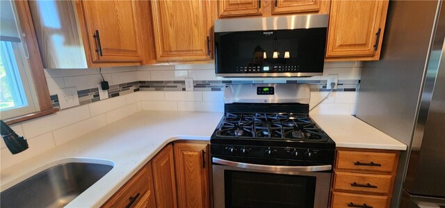 1006 N Koester Dr, Effingham, IL 62401 - kitchen with appliances with stainless steel finishes, a sink, tasteful backsplash, and light countertops